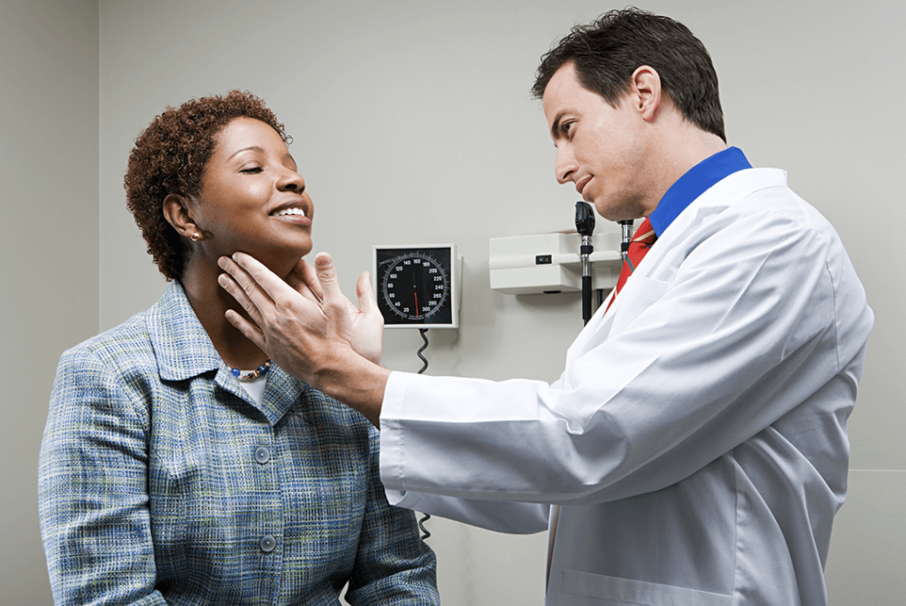 Médico examinando o pescoço de paciente.