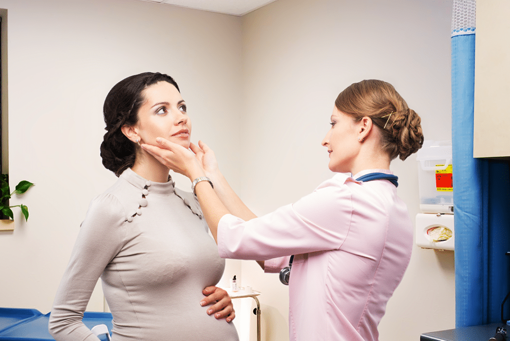 Médica examinando o pescoço de paciente.